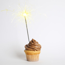 Birthday cupcake with sparkler on white background