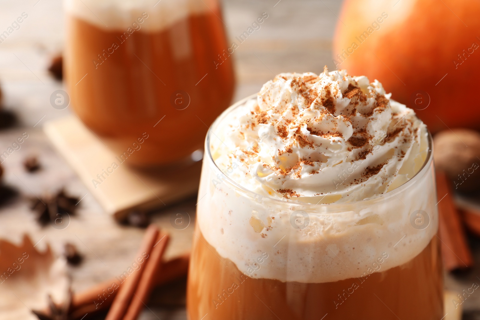 Photo of Glass with tasty pumpkin spice latte on table, closeup