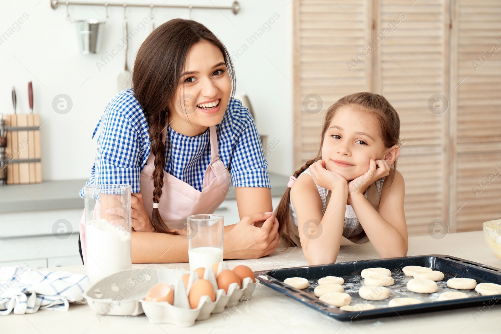 Photo of Mother and her daughter with cookie dough in kitchen