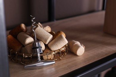 Many corks and corkscrew on wooden shelf, space for text