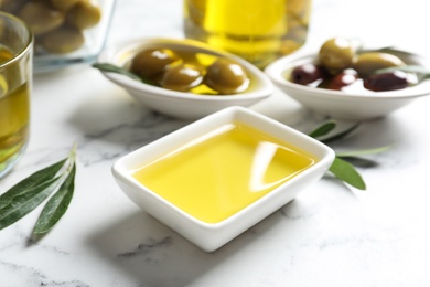 Bowls with olives and fresh oil on table