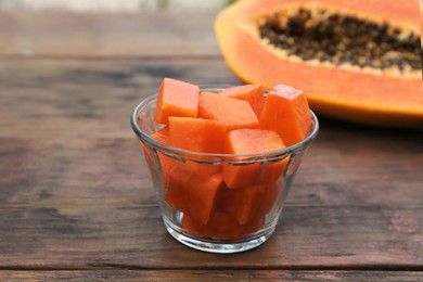 Photo of Tasty cut papaya fruits on wooden table, closeup