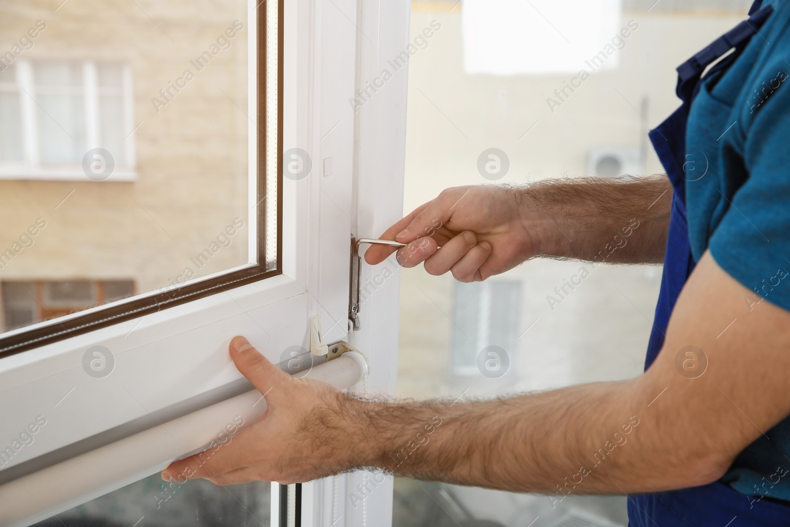 Photo of Construction worker installing plastic window in house, closeup