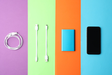Photo of USB charge cables and gadgets on color background, flat lay