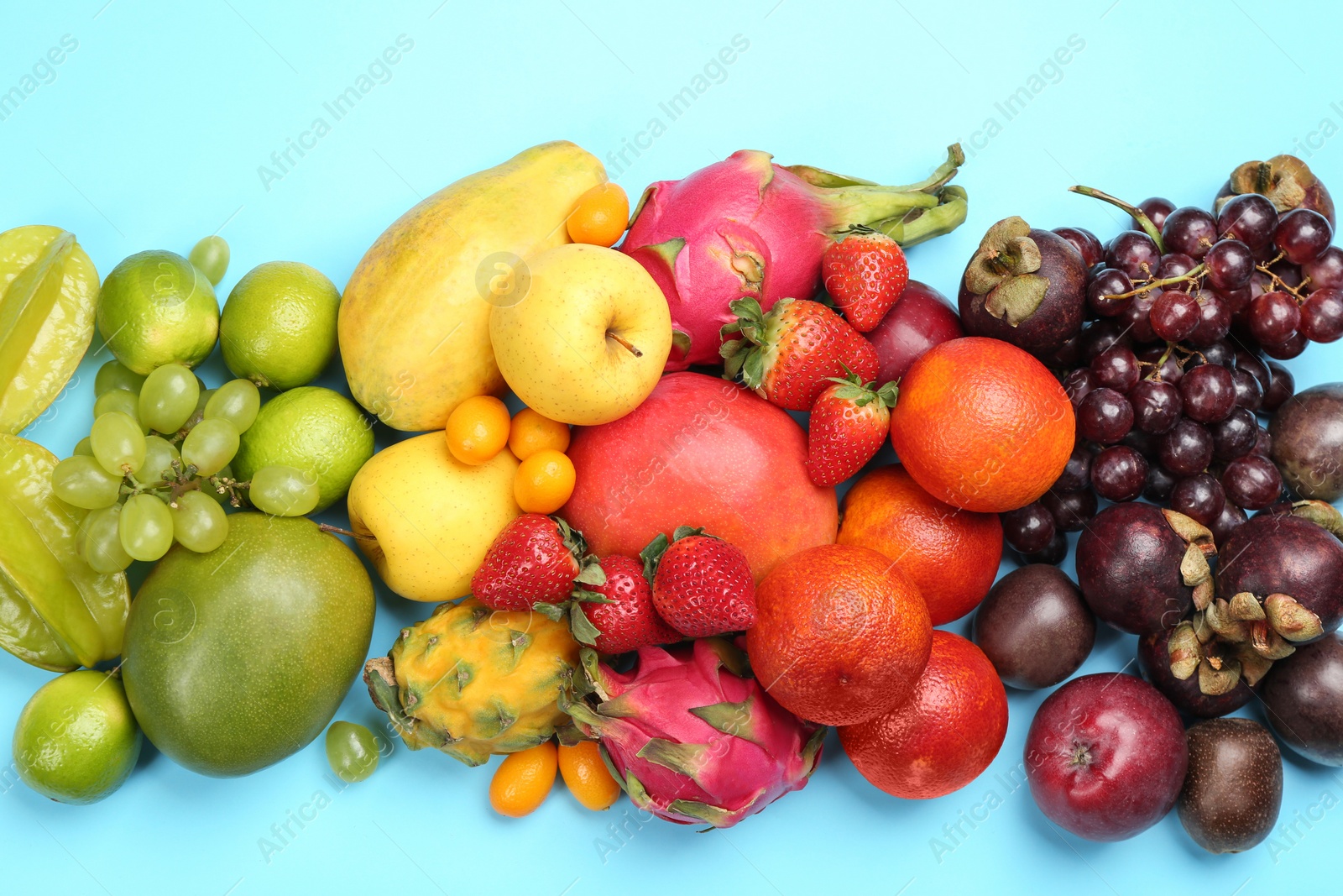 Photo of Many different delicious exotic fruits on light blue background, flat lay