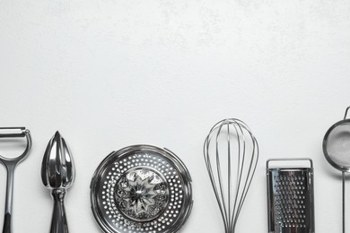 Photo of Set of different kitchen utensils on white table, flat lay. Space for text