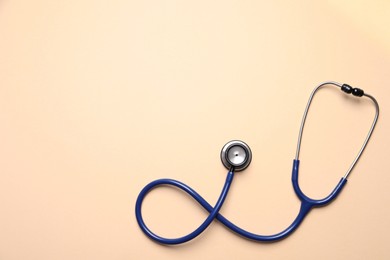 Photo of Stethoscope on beige background, top view. Space for text