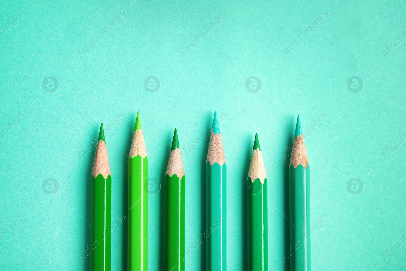 Photo of Flat lay composition with color pencils on turquoise background