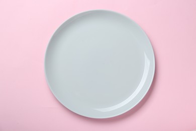 Photo of Empty ceramic plate on pink background, top view