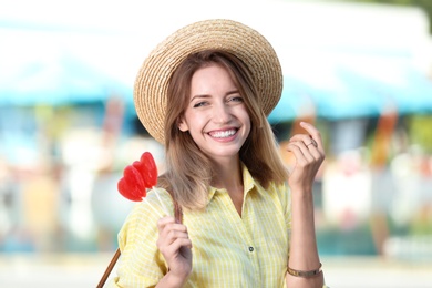 Beautiful smiling woman with candies on city street