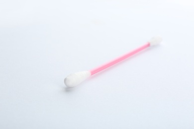 Photo of Pink plastic cotton swab on white background