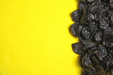 Photo of Tasty prunes on color background, top view with space for text. Dried fruit as healthy snack