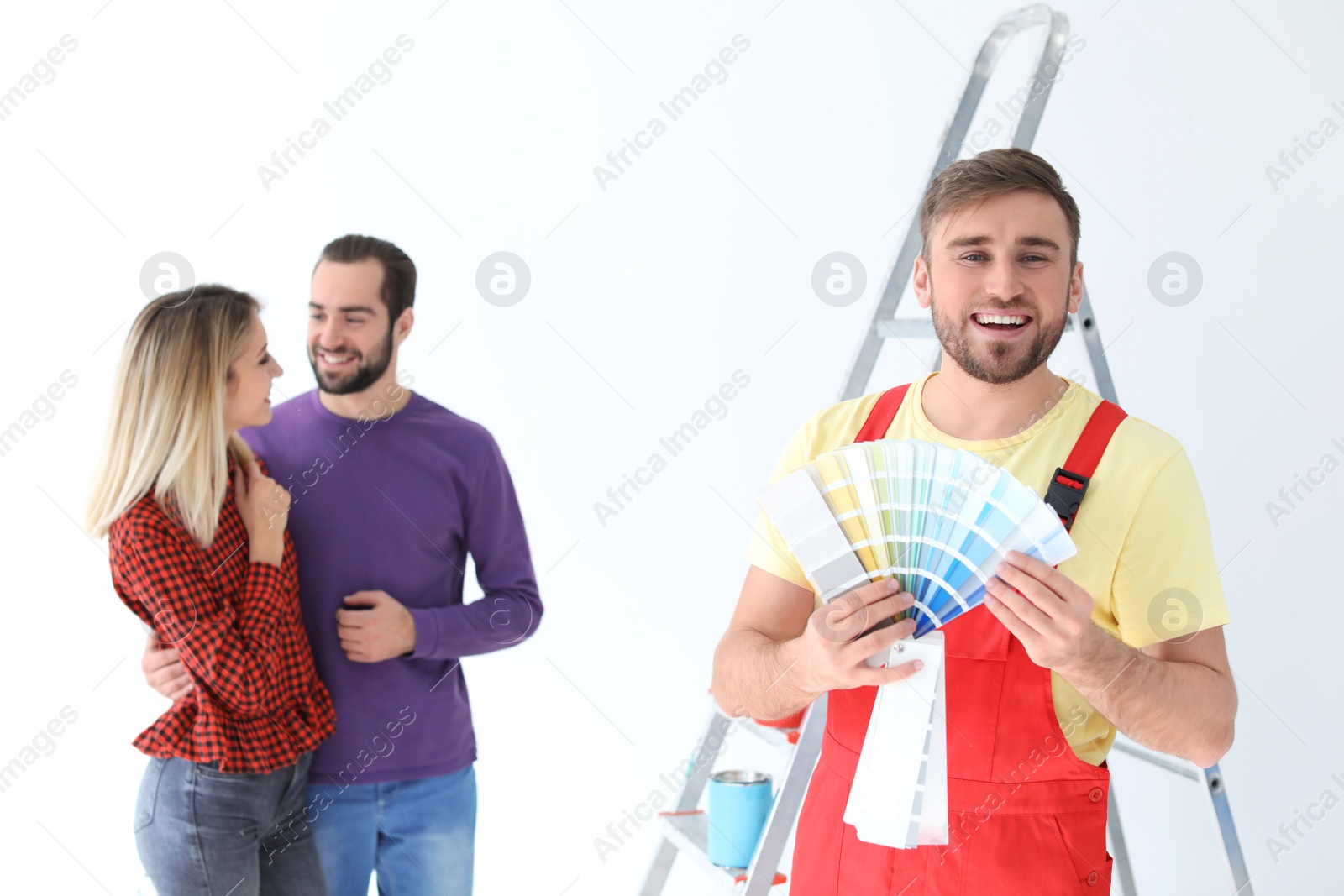 Photo of Male decorator and young couple with color palette on white background