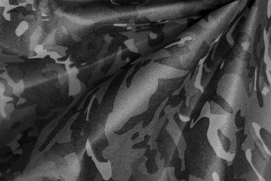 Texture of crumpled camouflage fabric as background, top view. Black and white effect