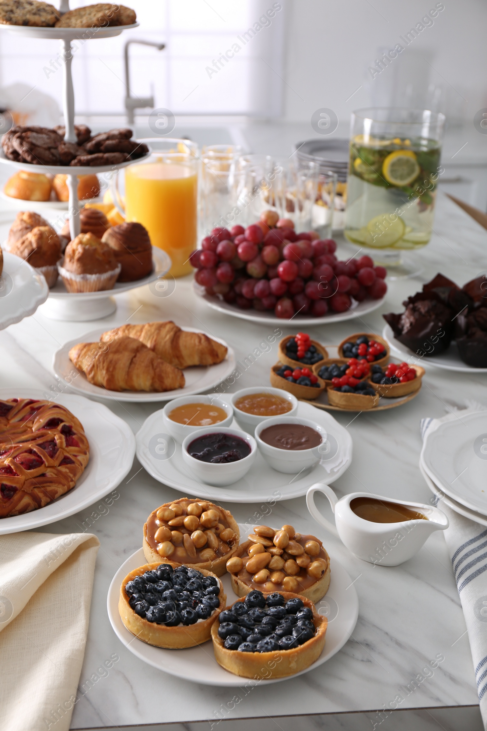 Photo of Variety of snacks on white marble table in buffet style indoors