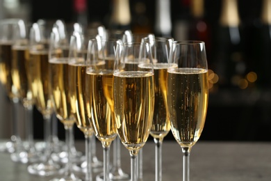 Photo of Many glasses of champagne on blurred background, closeup