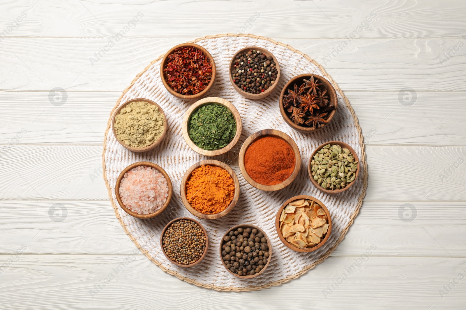 Photo of Bowls with different spices on white wooden table, top view