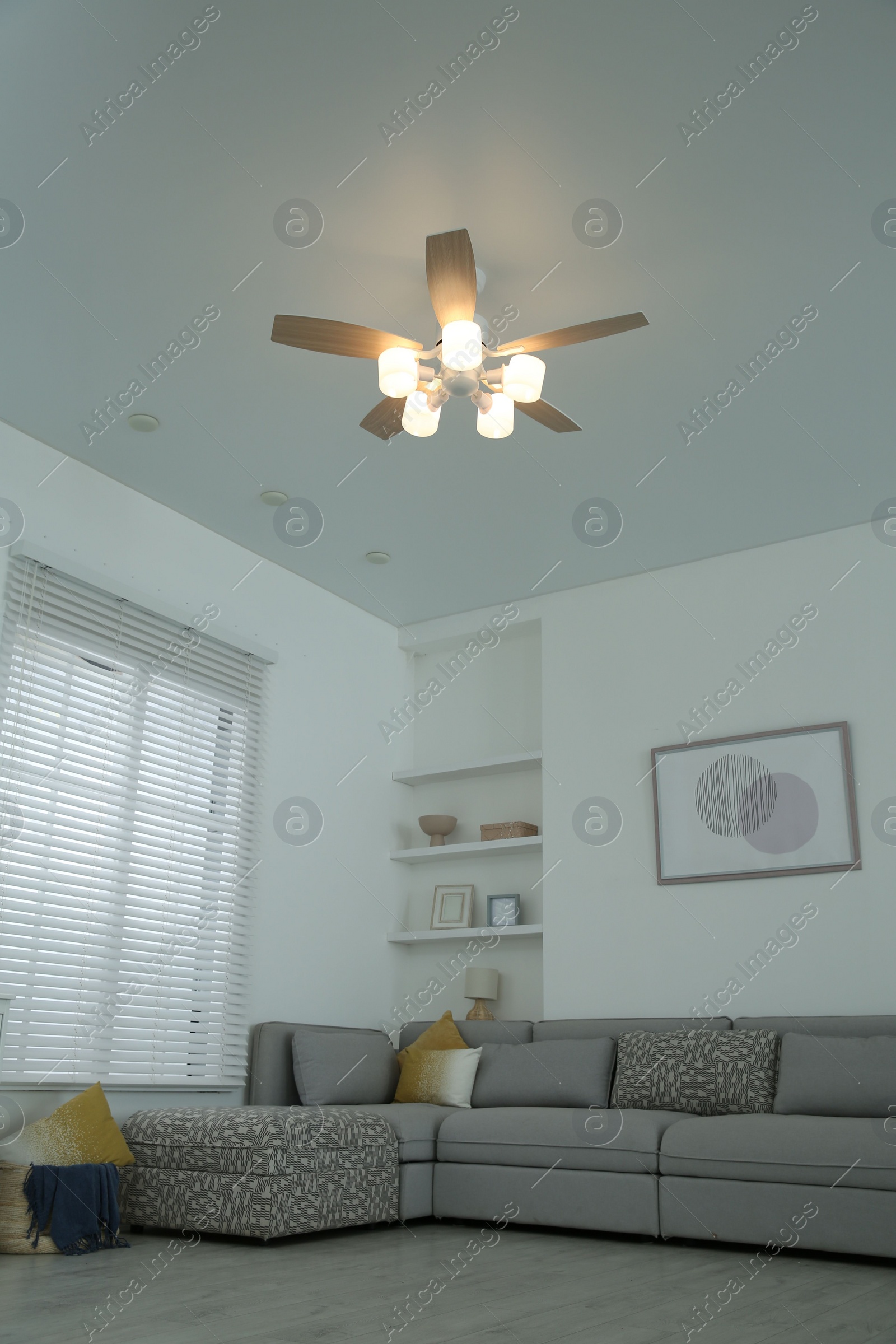 Photo of Comfortable furniture, ceiling fan and accessories in stylish living room