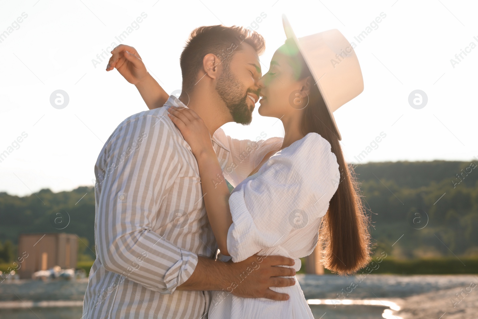 Photo of Romantic date. Beautiful couple kissing on sunny day outdoors