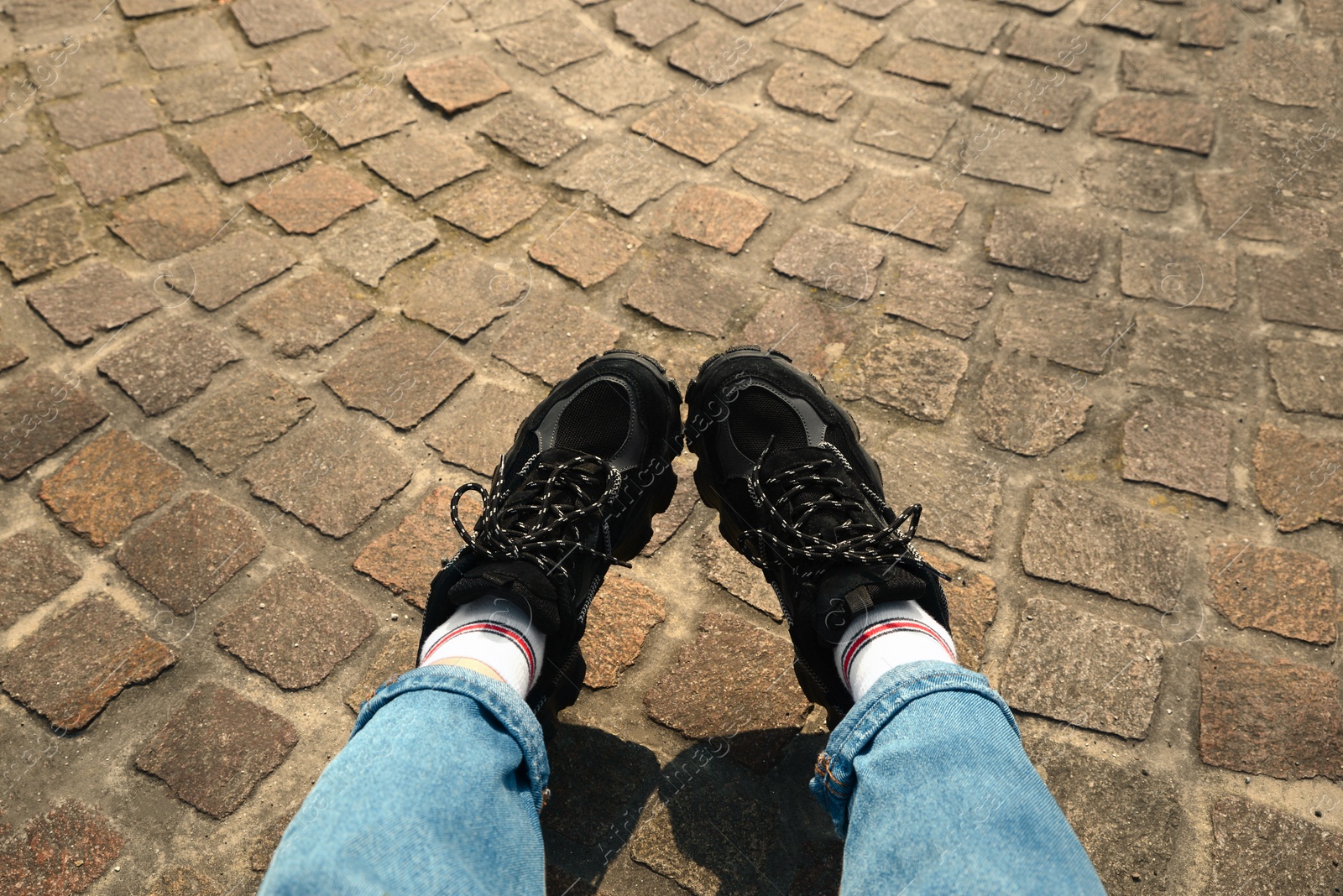 Photo of Woman in comfortable shoes and jeans outdoors, closeup