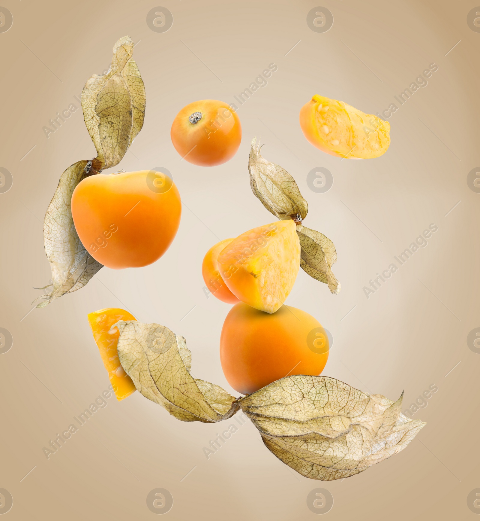 Image of Ripe orange physalis fruits with calyx falling on beige gradient background