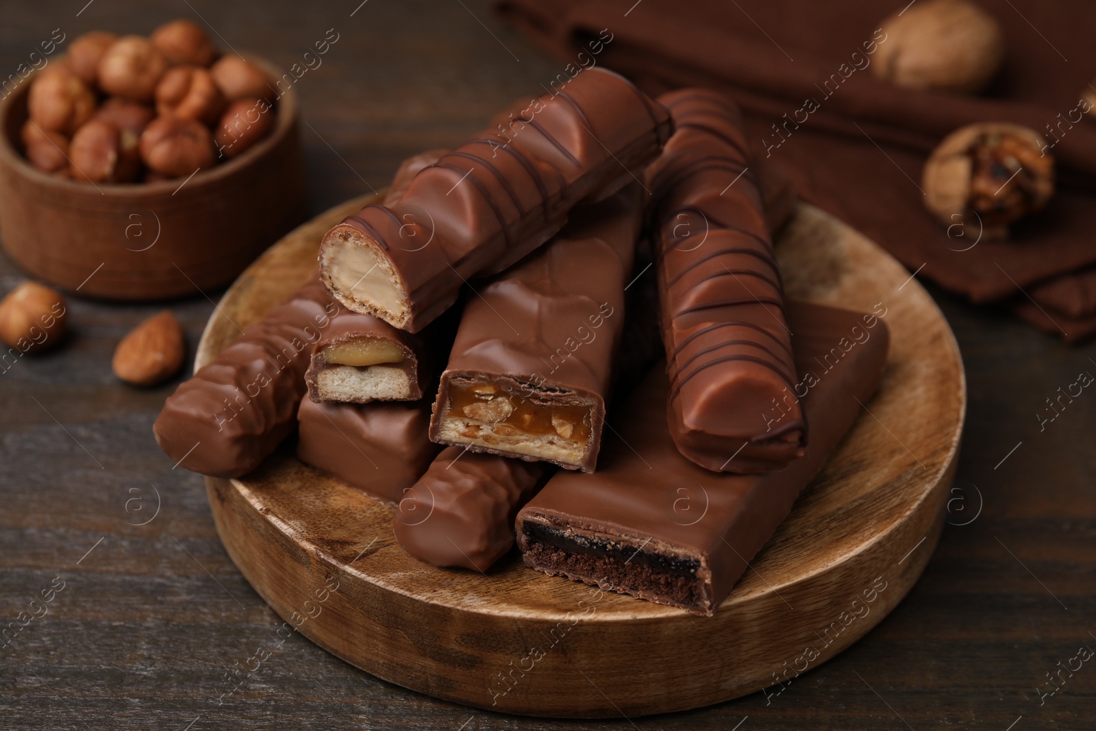 Photo of Pieces of different tasty chocolate bars on wooden table, closeup