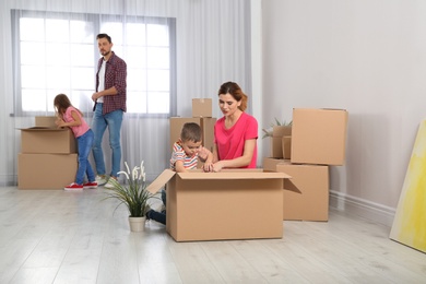 Happy family unpacking boxes in their new house. Moving day