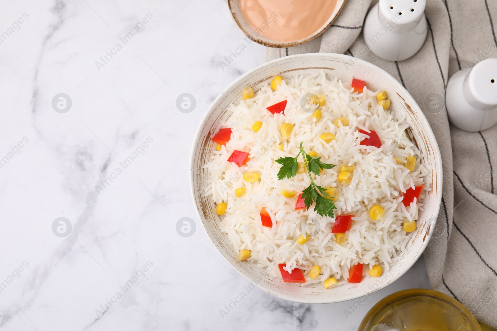 Photo of Bowl of delicious rice with vegetables and parsley on white marble table, flat lay. Space for text