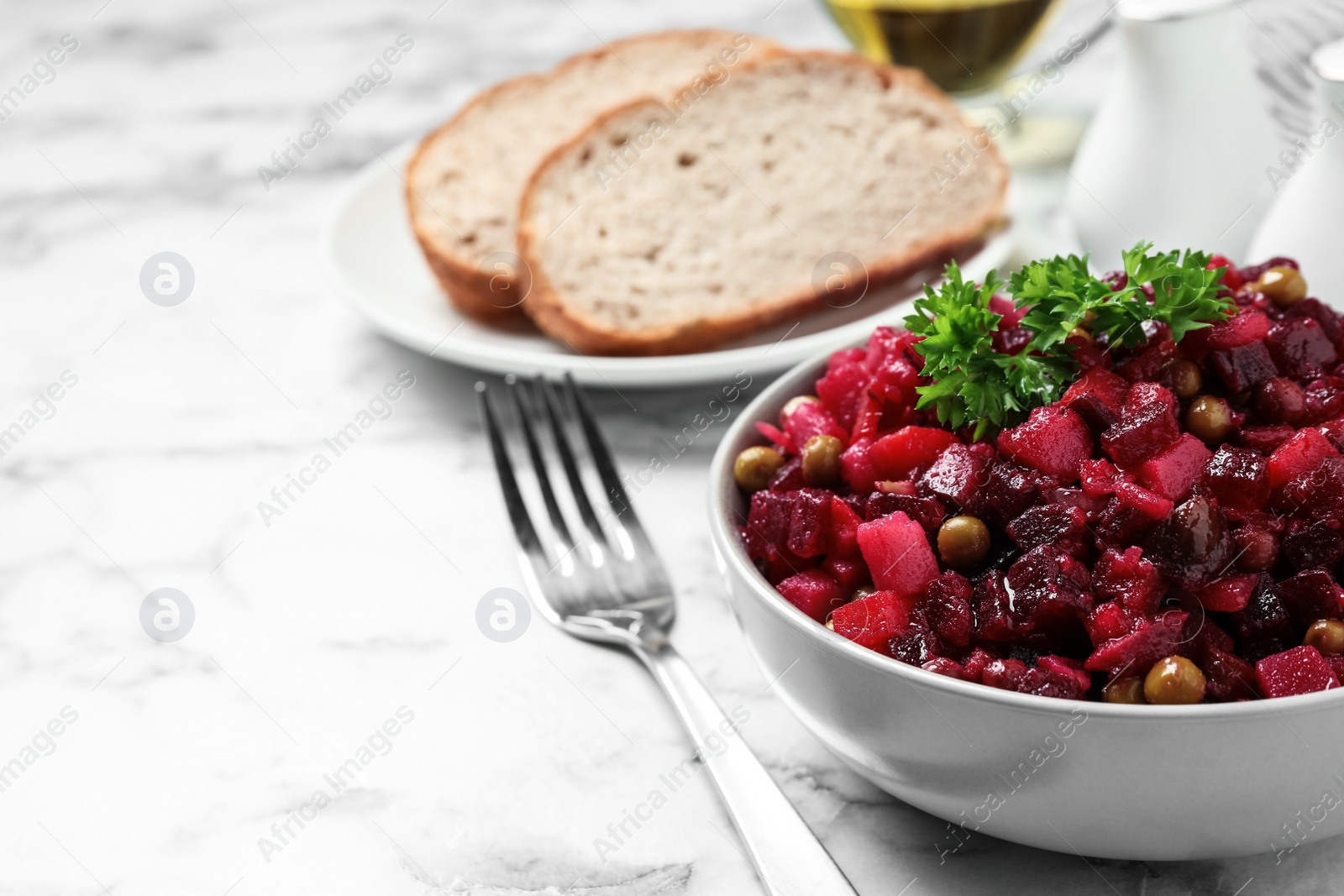 Photo of Traditional Russian salad vinaigrette served on white marble table. Space for text