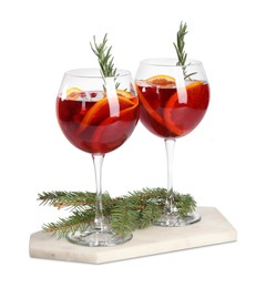 Photo of Christmas Sangria cocktail in glasses and fir tree branch isolated on white