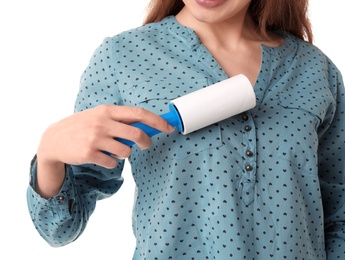 Young woman cleaning blouse with lint roller on white background