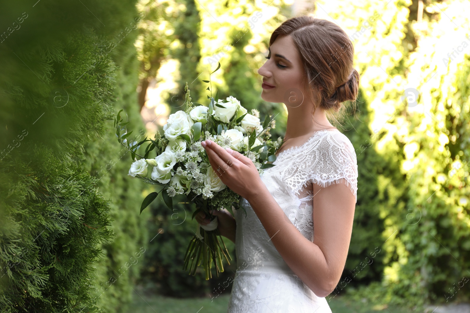 Photo of Gorgeous bride in beautiful wedding dress with bouquet outdoors