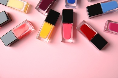 Photo of Bottles of nail polish on color background, top view with space for text