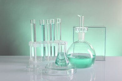 Laboratory analysis. Different glassware on table against color background