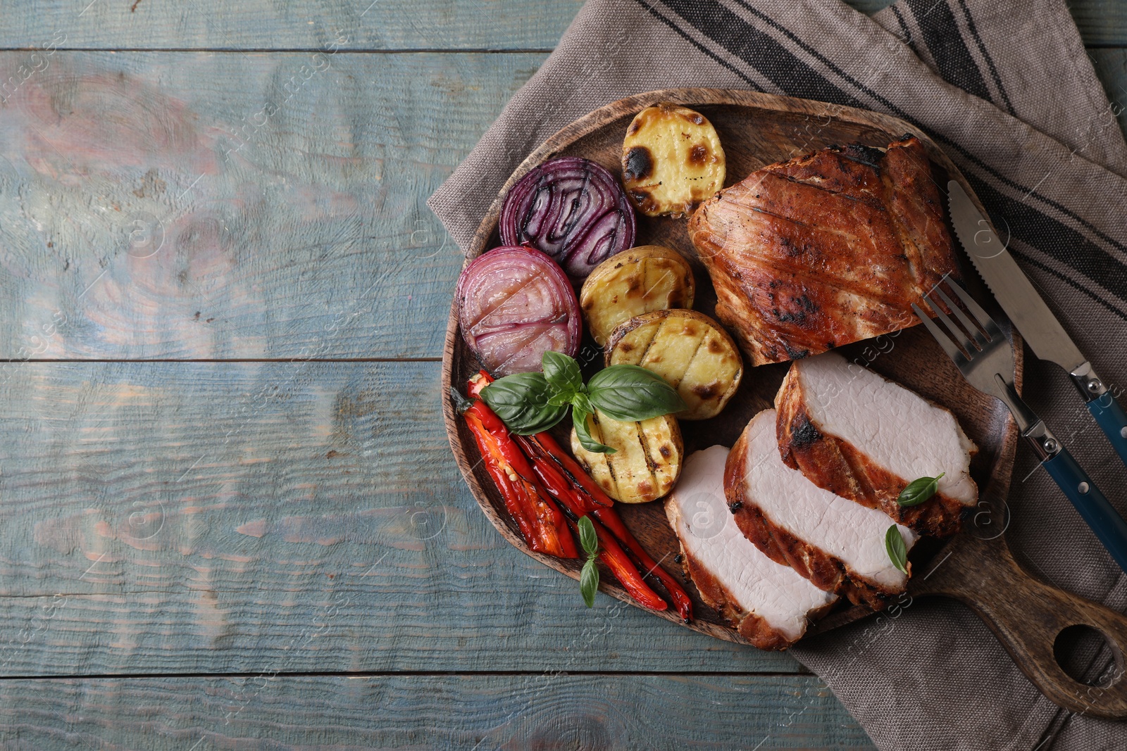 Photo of Delicious grilled meat and vegetables served on wooden table, top view. Space for text