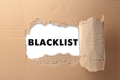 Word Blacklist on white paper, view through hole in cardboard