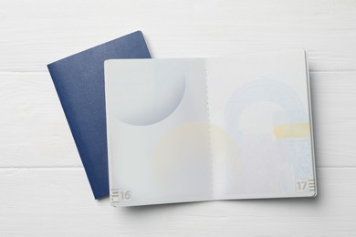 Photo of Blank passports on white wooden table, flat lay