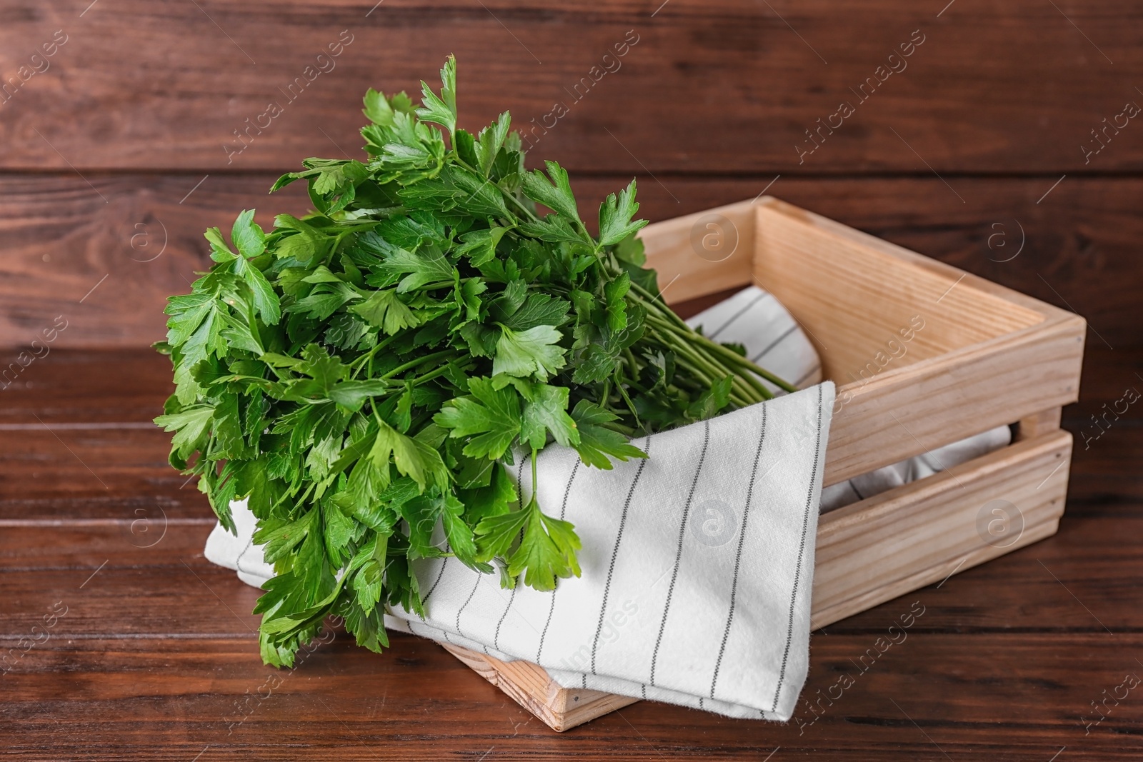 Photo of Crate with fresh green parsley on wooden table