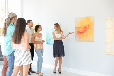 Group of people with guide at exhibition in art gallery