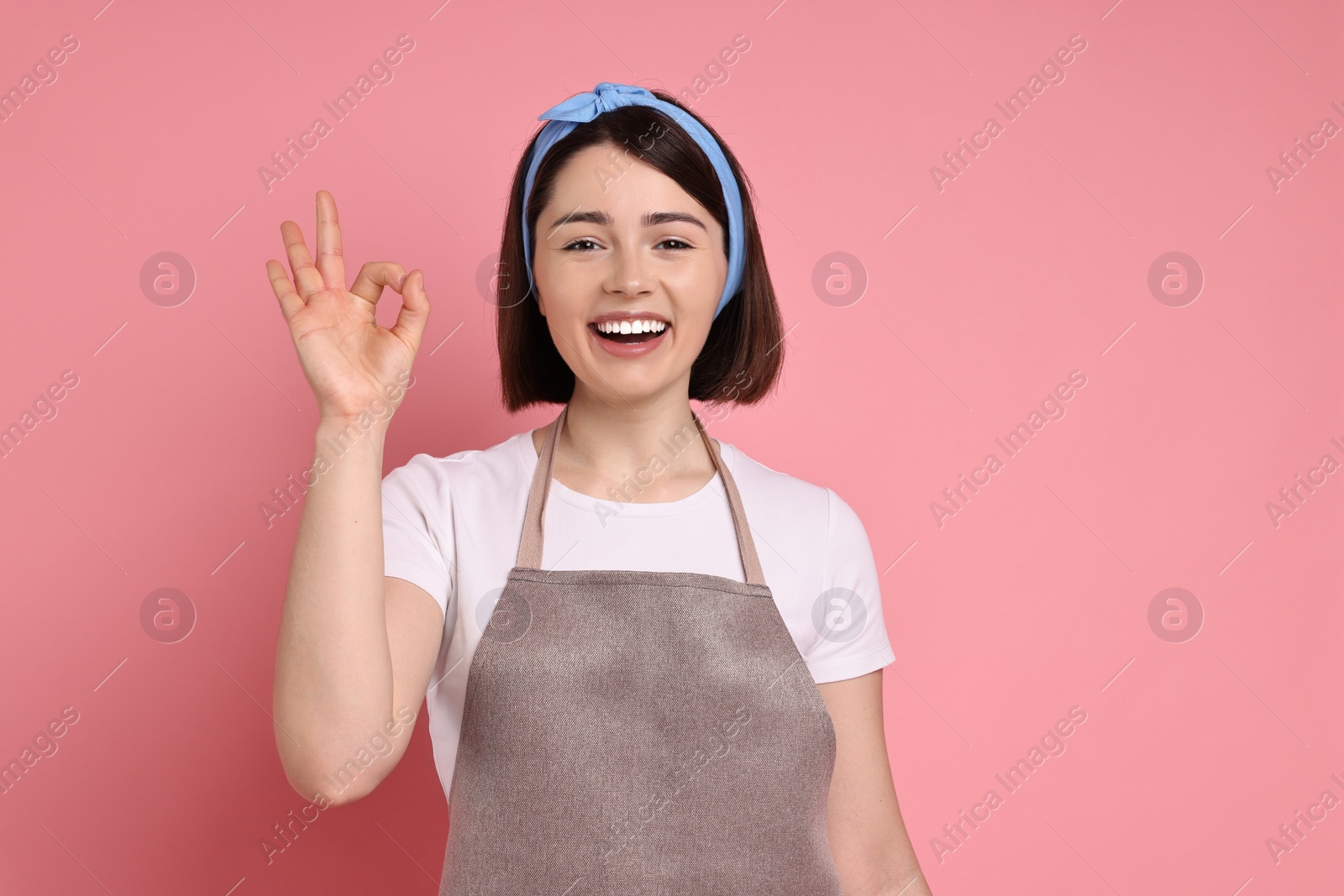 Photo of Happy confectioner showing ok gesture on pink background
