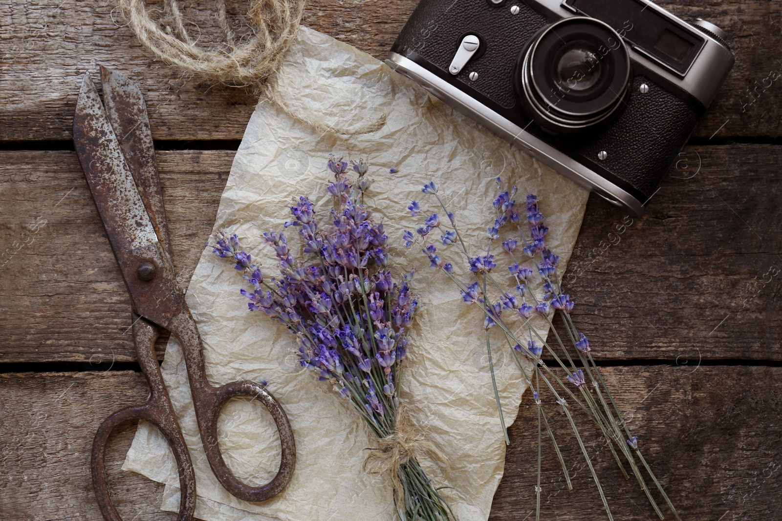 Photo of Beautiful lavender flowers, vintage camera and scissors on wooden table, flat lay