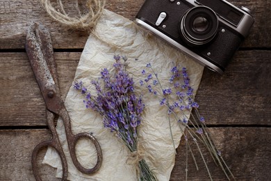 Photo of Beautiful lavender flowers, vintage camera and scissors on wooden table, flat lay