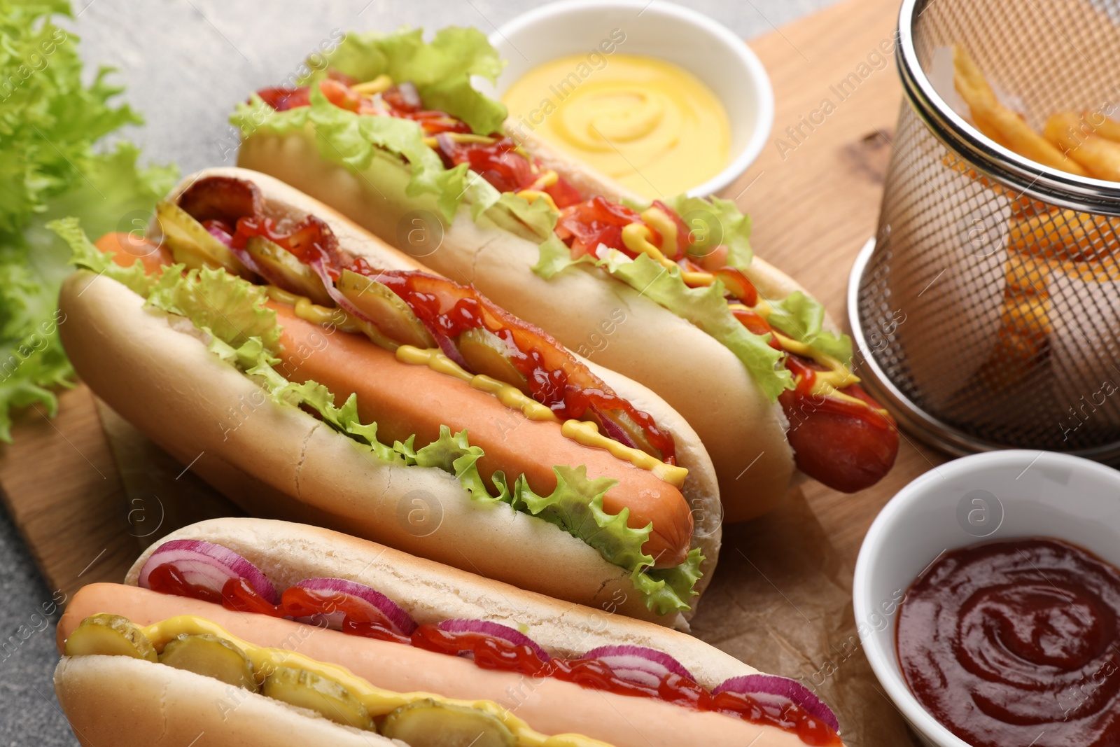 Photo of Delicious hot dogs with different toppings served on table, closeup