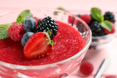 Photo of Delicious panna cotta with fruit coulis, fresh berries and mint in dessert bowl, closeup