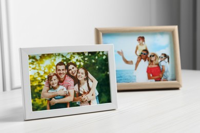 Framed family photos on white wooden table indoors. Space for text