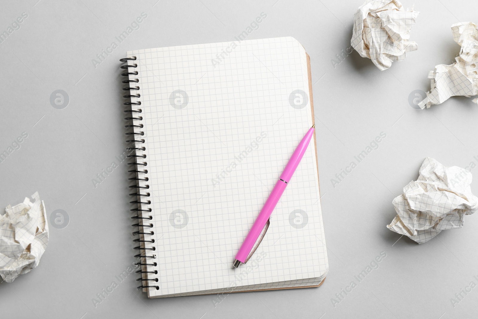 Photo of Notebook, pen and crumpled sheets of paper on light background, flat lay. Space for text