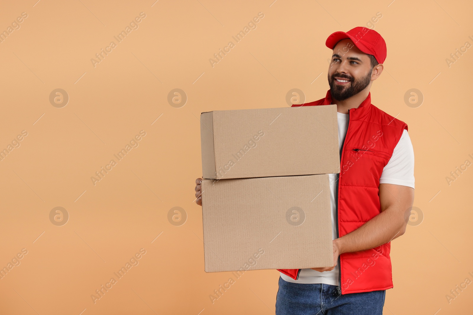 Photo of Happy young courier with parcels on light brown background. Space for text