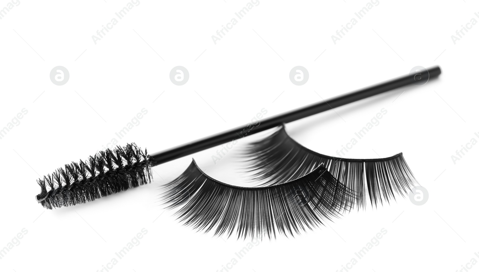 Photo of Fake eyelashes and brush on white background