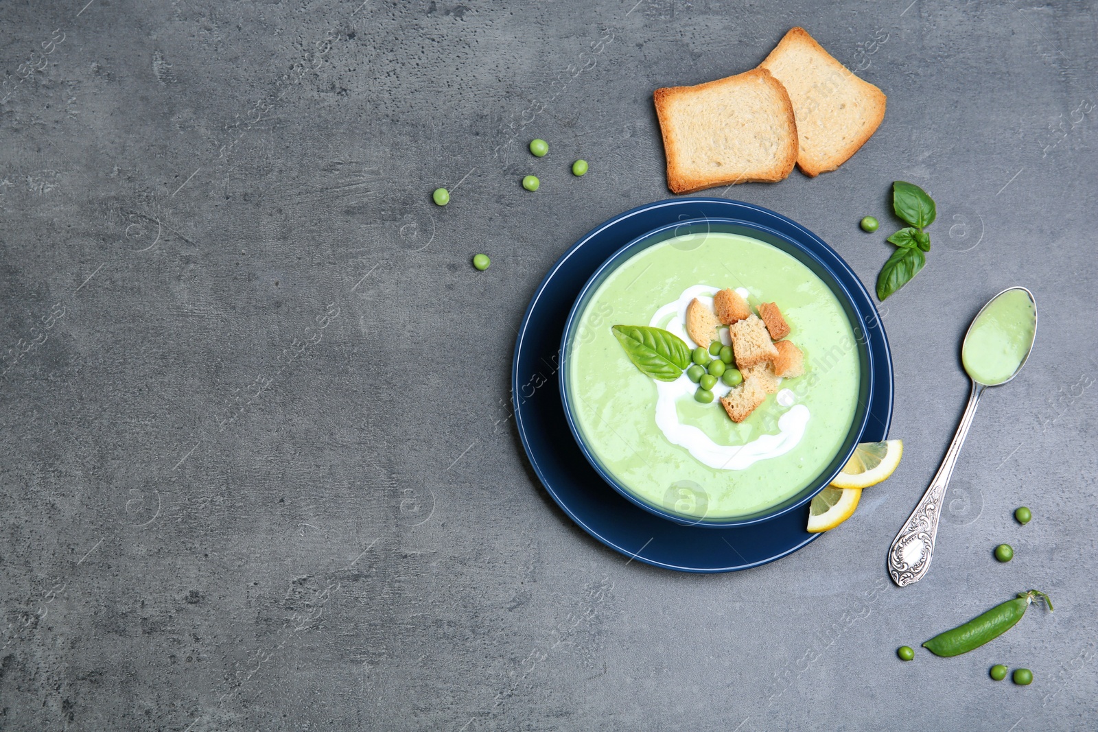 Photo of Flat lay composition with green pea soup on grey background