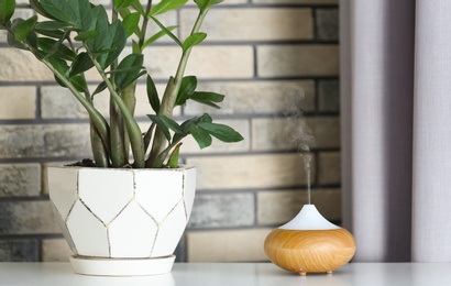 Photo of Aroma oil diffuser on table at home. Air freshener